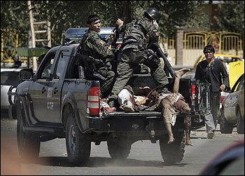 Afghan police carry the bodies of three suspected insurgents in the back of a truck after they were killed in a gunfight in Kabul, Wednesday, Aug. 19, 2009. Gunfire and explosions reverberated through the heart of the Afghan capital Wednesday on the eve of the presidential election after three militants with AK-47s rifles and hand grenades overran a bank. Police stormed the building and killed the three insurgents, officials said. (AP Photo/Kevin Frayer)